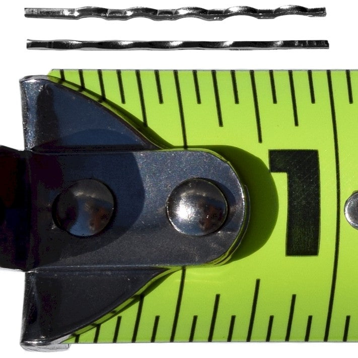 Two 1-inch serrated stainless steel needles above a tape measure, showing their size for mixing into castable refractory