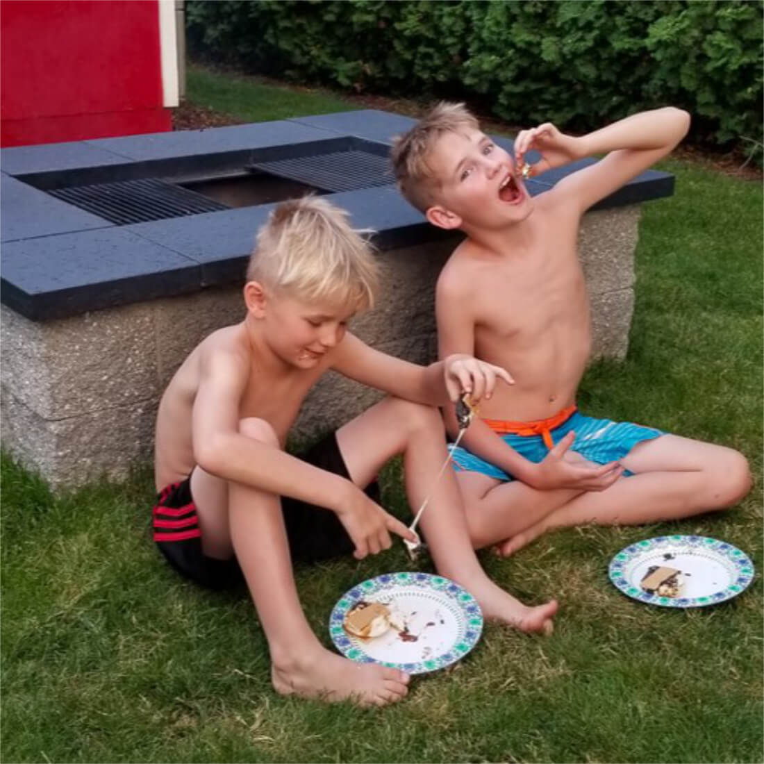Boys enjoying s'mores next to a DIY fire pit grill
